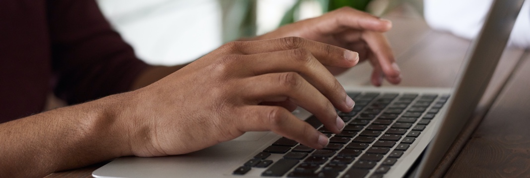 a man is typing on his laptop