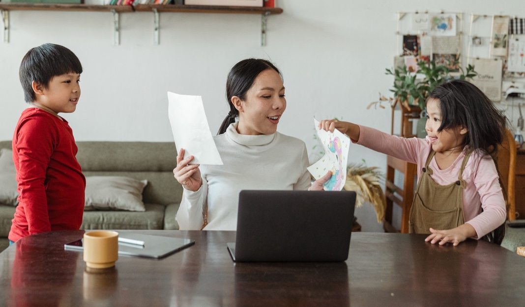 a woman at home working and talking to children